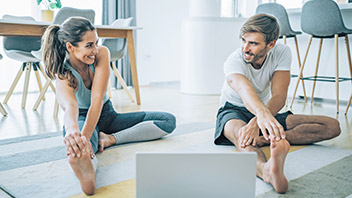 Paar macht Sport am Laptop zu Hause