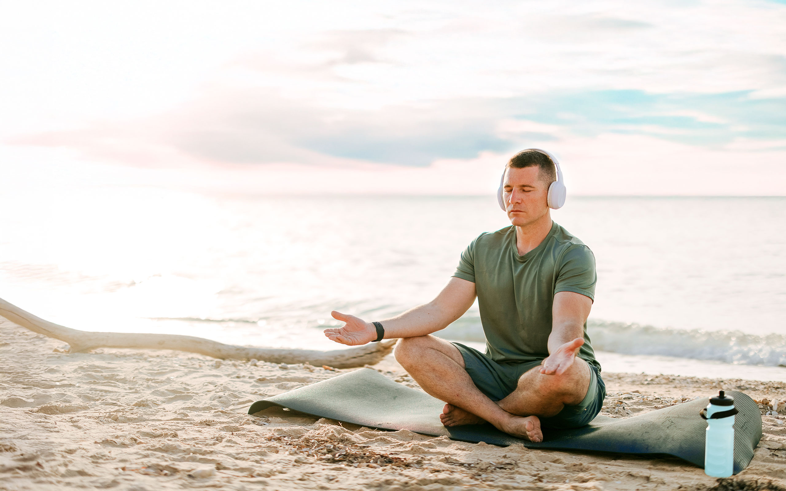 Mann in Yogapose am Meer