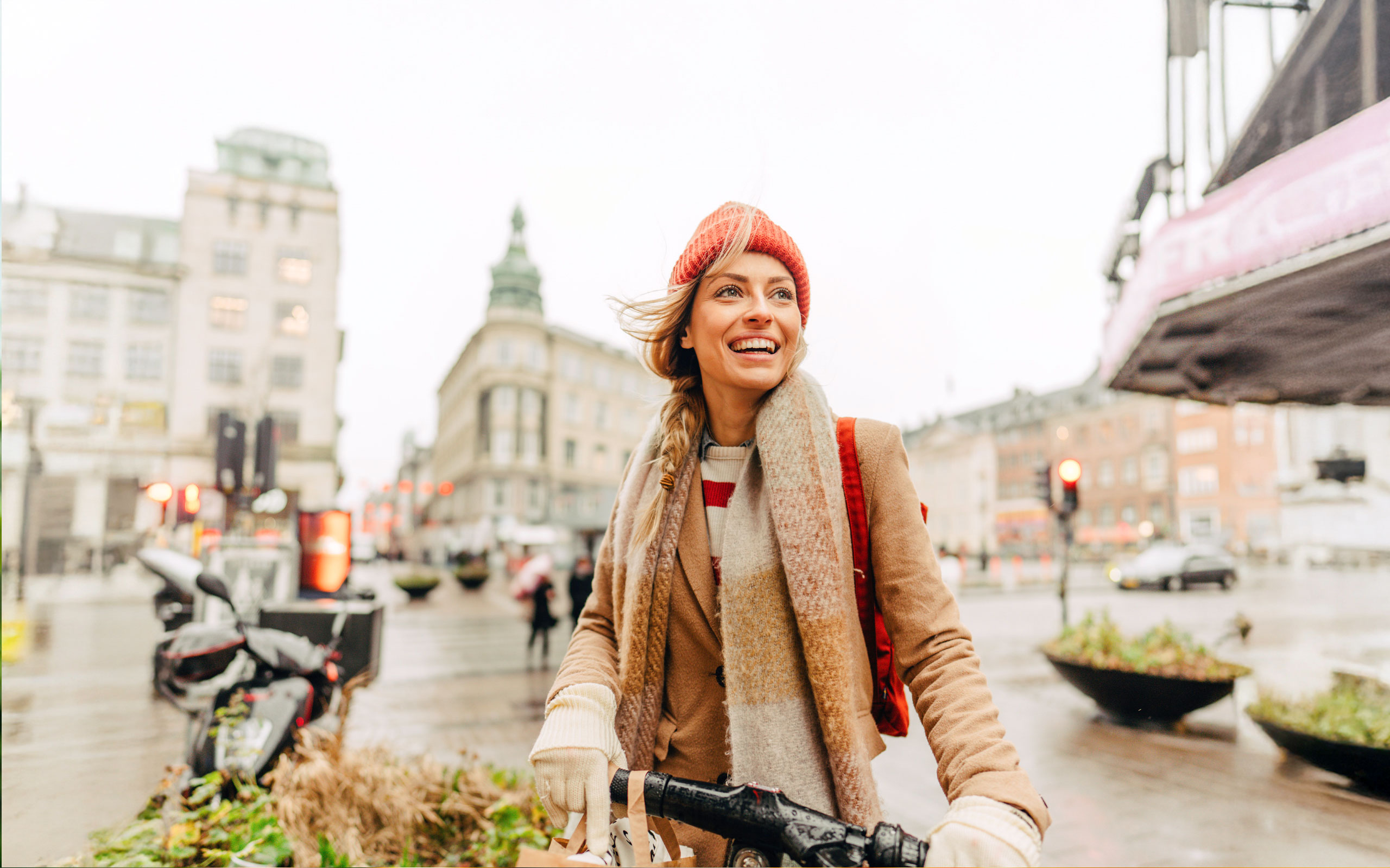 Frau mit Mütze in der Stadt auf dem Fahrrad