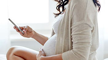 Schwangere Frau mit Handy