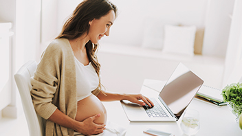Frau am Laptop auf Hebammensuche bei der HEK