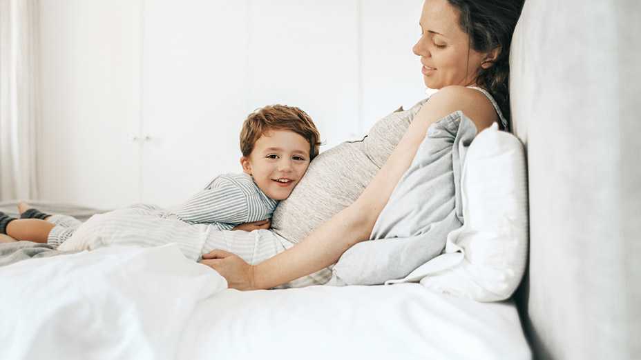 Schwangere Frau im Bett mit aktiver Hebammen Rufbereitschaft
