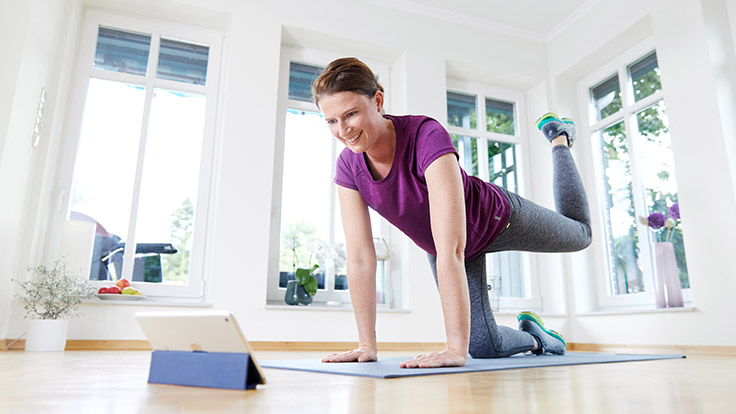 Frau macht Fitnessübung mit Herodikus App über die HEK