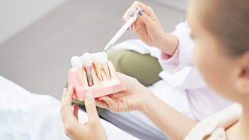 Frau zeigt Zahn-Implantat