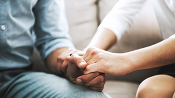 Pärchen Händchen haltend auf der Couch