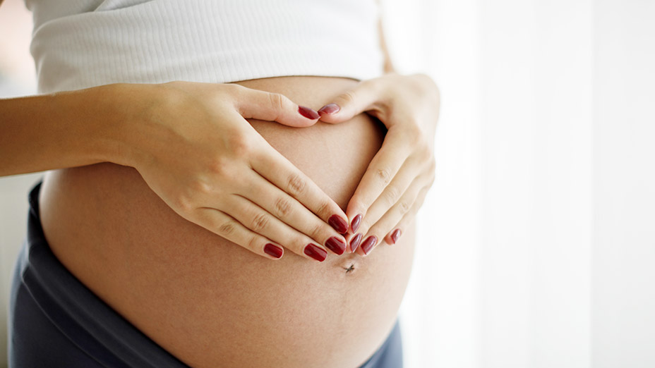 schwangerschaftsleistungen-a-z.gr Schwangere Frau mit Händen auf dem Babybauch
